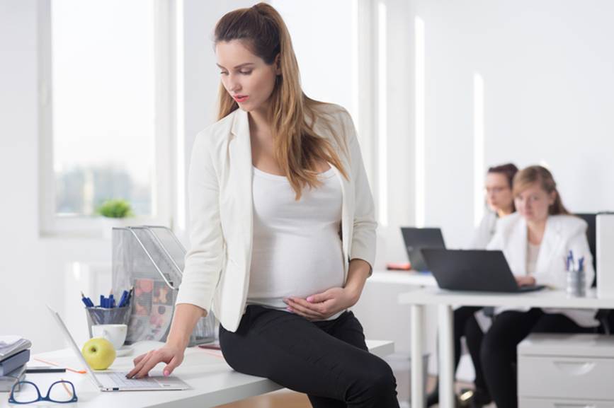 Pregnant woman working on laptop - Pregnancy Discrimination